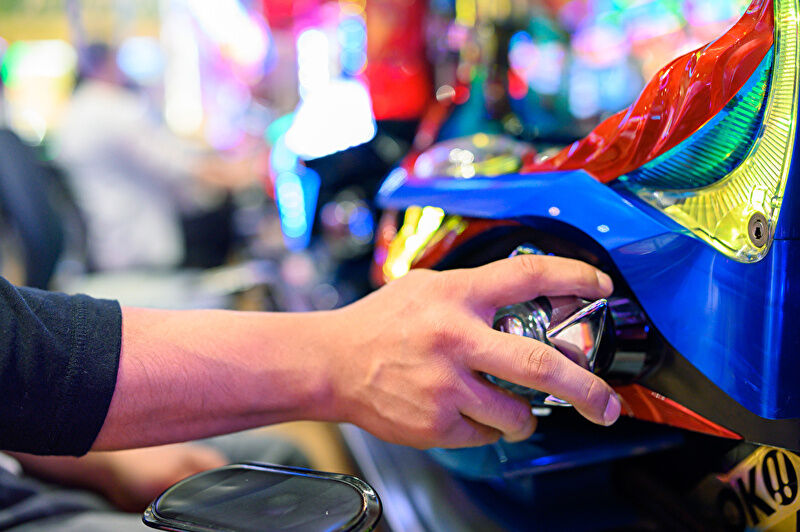 パチンコ台のハンドルを握って遊技している手元の画像。実際にパチンコを打っている様子を表した写真。