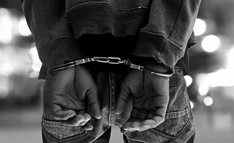 パチンコ店でルールやマナーを破った結果、トラブルとなり手錠をかけられる状況をイメージした画像。